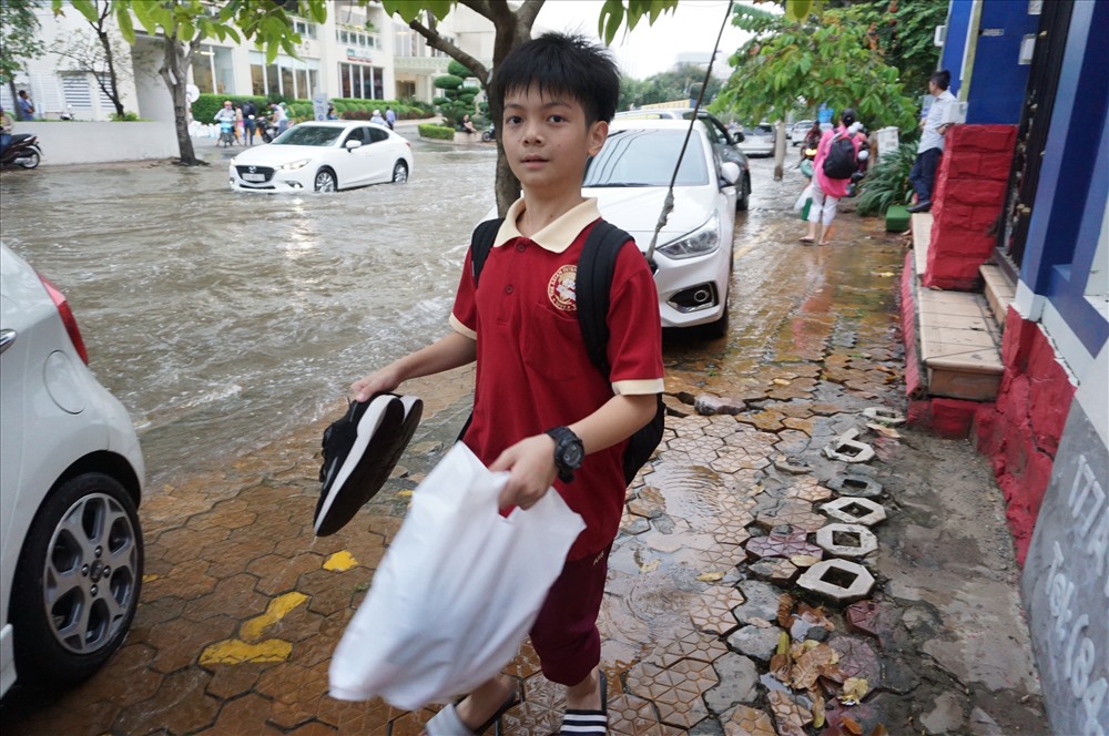 Do đã quen với việc ngập nước mỗi khi triều cường dâng cao nên nhiều em học sinh trường quốc tế trong khu Thảo Điền mang theo dép để đi thay cho giầy cho khỏi bị ướt.