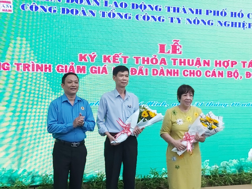 Chủ tịch CĐ Tcty Nông nghiệp Sài Gòn Đnh Anh Sâm tặng hoa cho đại diện hai công ty cam kết bán hàng giảm giá cho đoàn viên CĐ. Ảnh Nam Dương
