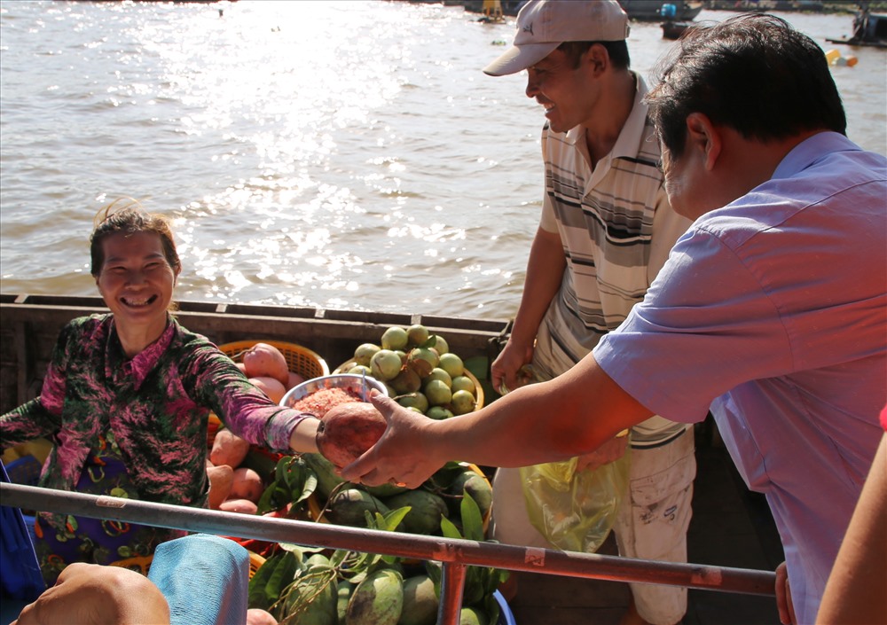 Các ghe cập mạn thuyền bán trái cây cho khách du lịch tại chợ nổi Cái Răng.  Ảnh: H.Thơ