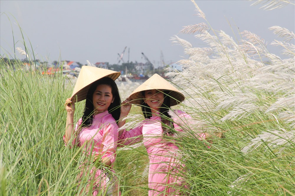 Với tàu áo dài và chiếc nón lá truyền thống, cộng hưởng với màu trắng của hoa lau tôn lên vẻ đẹp thanh lịch, thanh bình của làng quê Việt Nam. Ảnh: Thanh Chung