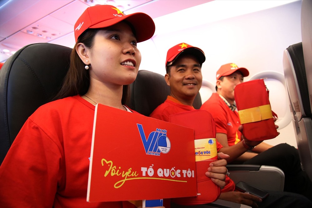 Một hành khách khoe chiếc áo in dòng chữ “Tôi yêu Tổ quốc tôi” là quà tặng của Vietjet trên tàu bay “Tôi yêu Tổ quốc tôi”. Ảnh: VJA