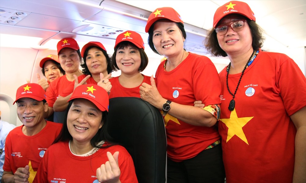 Một nhóm hành khách chụp ảnh kỷ niệm trên tàu bay “Tôi yêu Tổ quốc tôi” của Vietjet. Ảnh: VJA