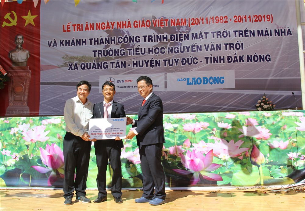 Đại diện Báo Lao Động, VNECPC tặng bảng tượng trưng công trình năng lượng mặt trời điện áp mái với giá trị hơn 250 triệu đồng. Ảnh: HL