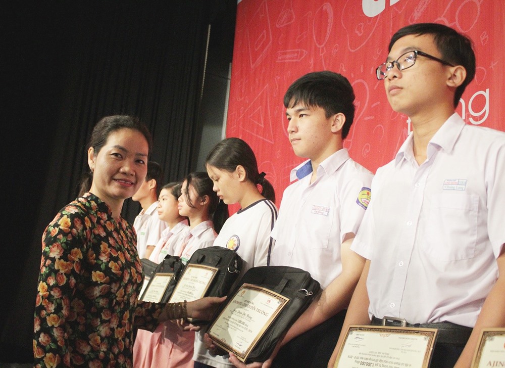Bà Lê Thị Hòa Thuận - Ủy viên thường trực Ủy ban Mặt trận Tổ quốc tỉnh Đồng Nai - trao học bổng cho các em học sinh (ảnh:A.T).