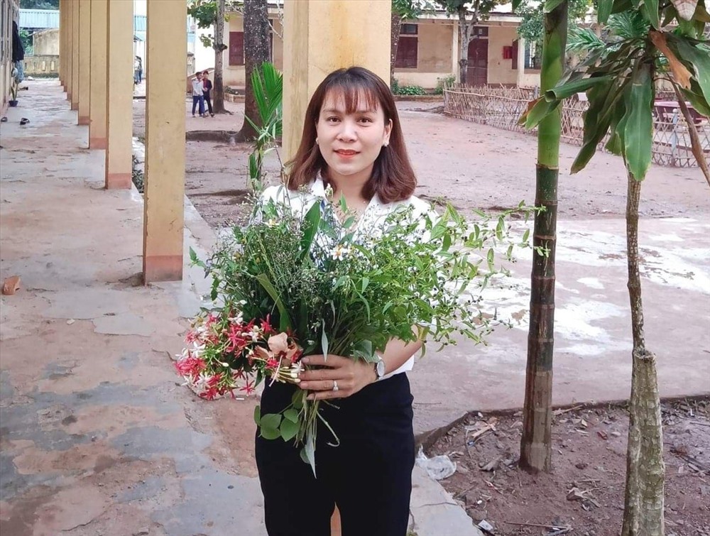 Nữ giáo viên Hoàng Thị Kim Chung - Trường Tiểu học và Trung học cơ sở A Xing bên bó hoa dại của học sinh tặng ngày 20.11. Ảnh: GV.