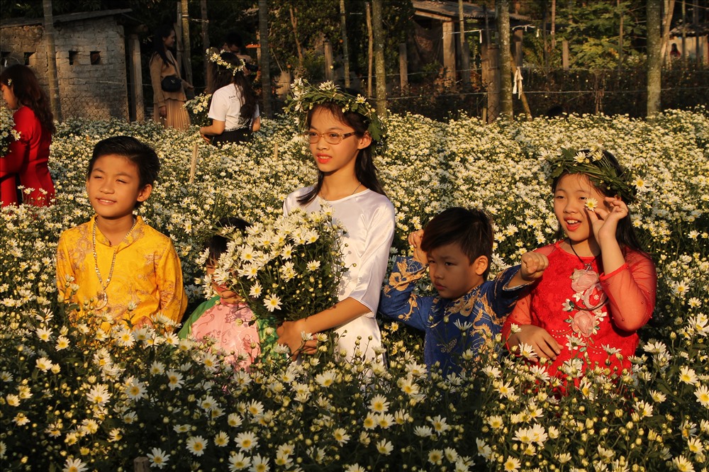 Các em nhỏ tự tin tạo dáng giữa vườn hoạ mi rực nắng. Ảnh MD