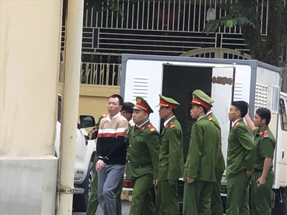 Đối tượng Phạm Văn Nhiệm được cảnh sát dẫn giải đến toà. Ảnh: C.N