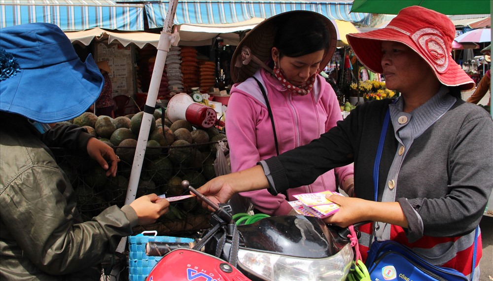 Người phụ nữ nghèo bán vé số ở chợ Đồng Xoài. Ảnh: Đình Trọng