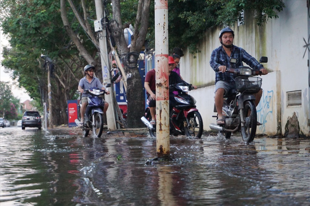 Nhiều người phải chạy xe máy lên vỉa hè để tránh đoạn ngập sâu.