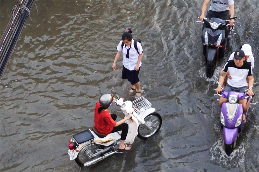 Học sinh bì bõm lội nước về trên đường Trần Xuân Soạn.  Ảnh: Minh Quân
