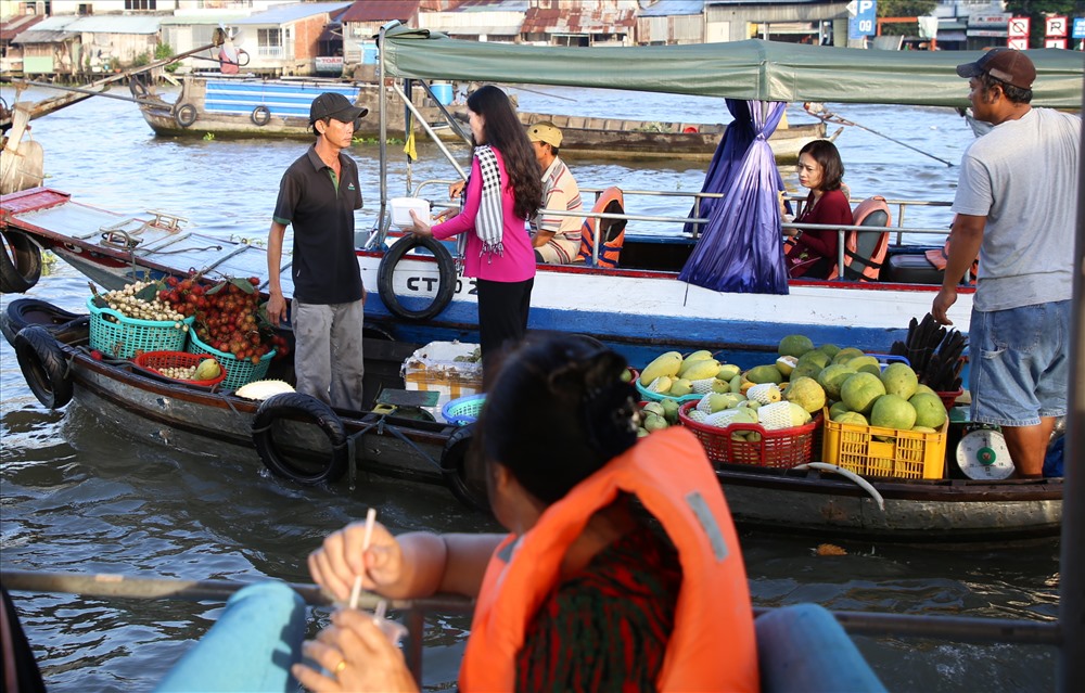 Trên các ghe bán hàng, một số phụ nữ mang áo bà ba, đeo khăn