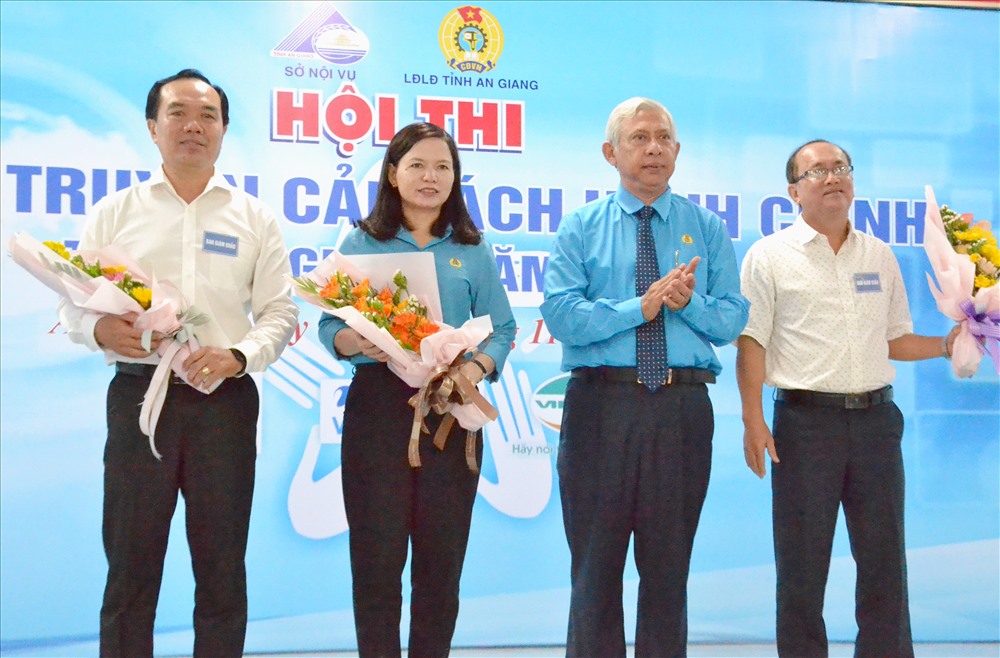 Chủ tịch LĐLĐ An Giang Nguyễn Thiện Phú - Trưởng ban tổ chức hội thi tặng hoa cho Ban giám khảo. Ảnh: Lục Tùng
