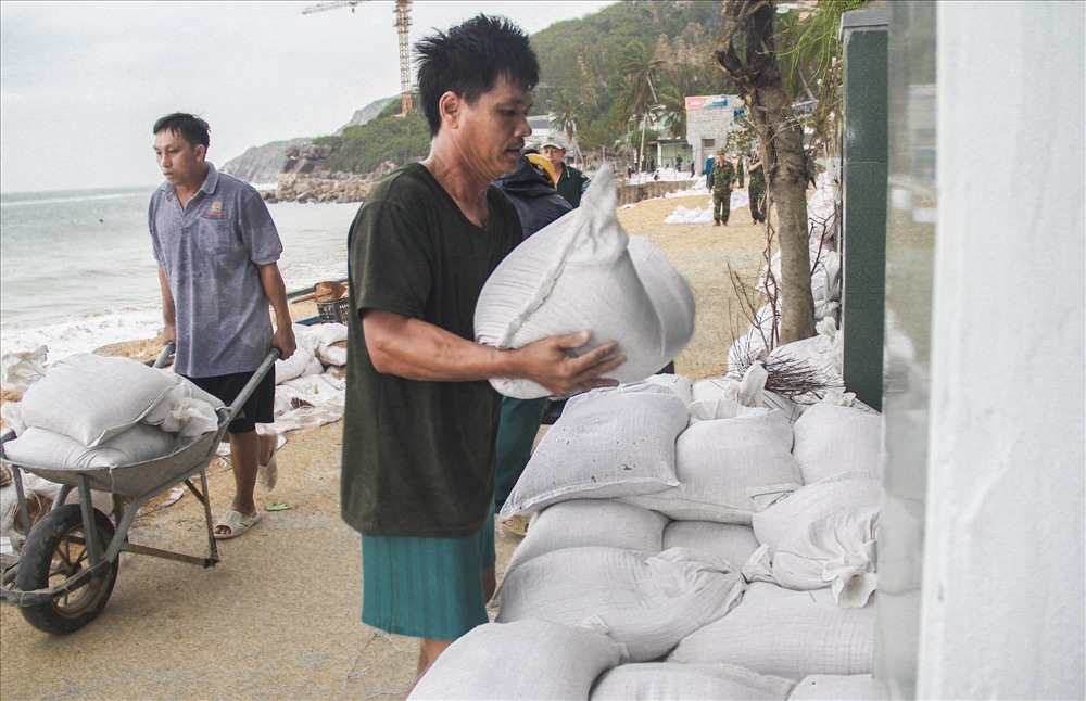 Người dân sử dụng bao cát chằng trước nhà để đối phó với sóng biển cao khi bão số 6 đổ bộ.
