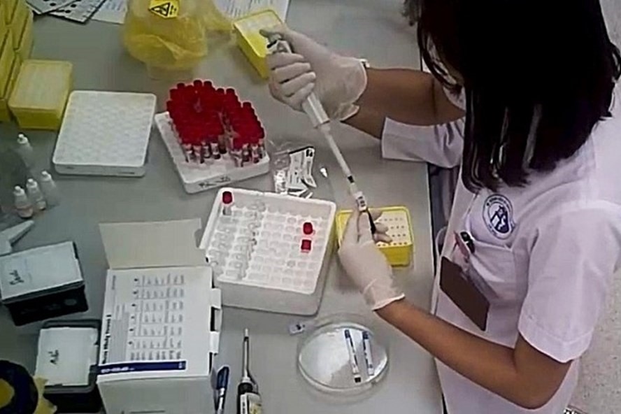 Nhân viên y tế trộn mẫu máu của bệnh nhân vào với nhau. Ảnh: chụp màn hình từ phóng sự điều tra của VTV24