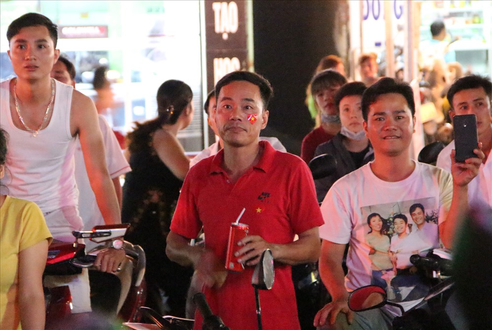 Ông Nguyễn Tiến Quyền trông xe nhưng đứng ngồi không yên theo dõi trận đấu.