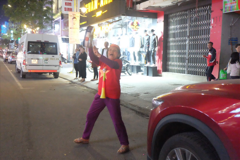 Một phụ nữ lớn tuổi ra đường ăn mừng chiến thắng. ảnh: H.Vinh