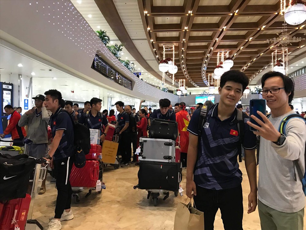 Đức Chinh chụp ảnh cùng người hâm mộ tại sân bay. Ảnh Hoàng Phạm