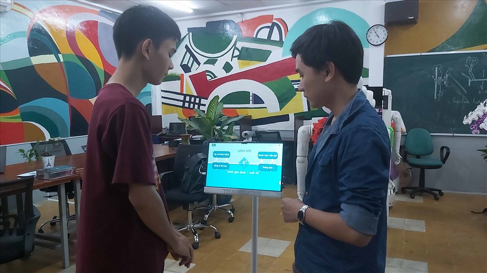 Hai sinh viên Nam và Hải đang “nói chuyện” với robot. Ảnh: QUỲNH NHƯ