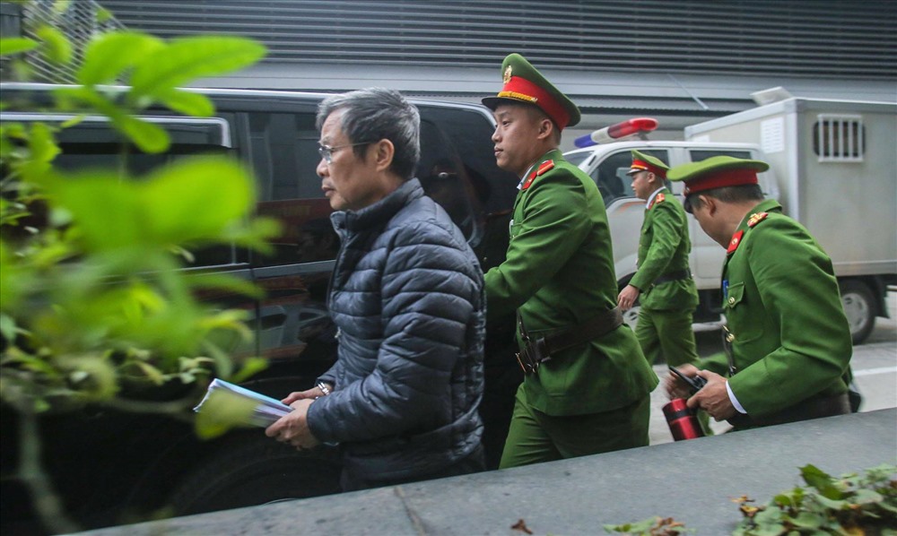 Ông Nguyễn Bắc Son bị tạm giam, bị cảnh sát dẫn giải vào phòng xử.