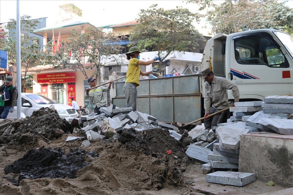 Các công nhân gấp rút vận chuyển rác thải xây dựng để kịp dự án.