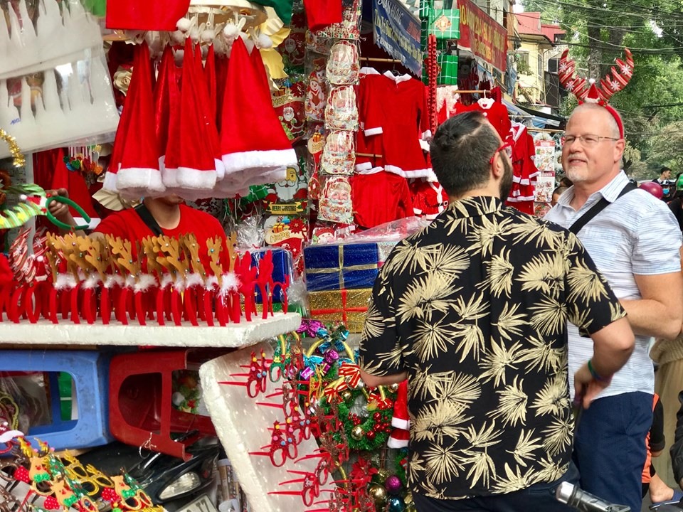Du khách nước ngoài hào hứng mua sắm đồ Giáng sinh ở khu vực phố cổ.