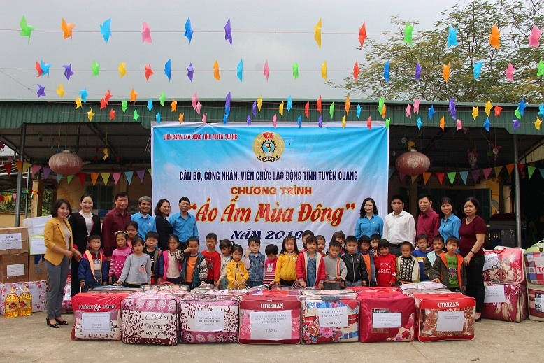 Đồng chí Nông Minh Hiền - Phó Chủ tịch Liên đoàn lao động tỉnh Tuyên Quang tặng chăn ấm, quần áo, bít tất cho trẻ em vùng cao. Ảnh: T.Q