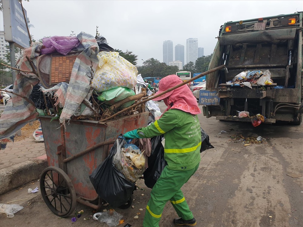 Công nhân vệ sinh thu dọn rác, đổ lên xe trên đường Phạm Văn Bạch.