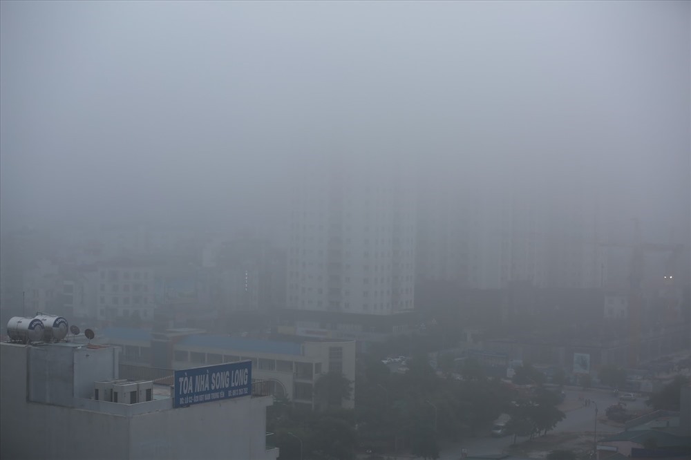 Nhiều tòa nhà “mất nóc” trong lớp sương mù dày đặc. Ảnh: Minh Hà