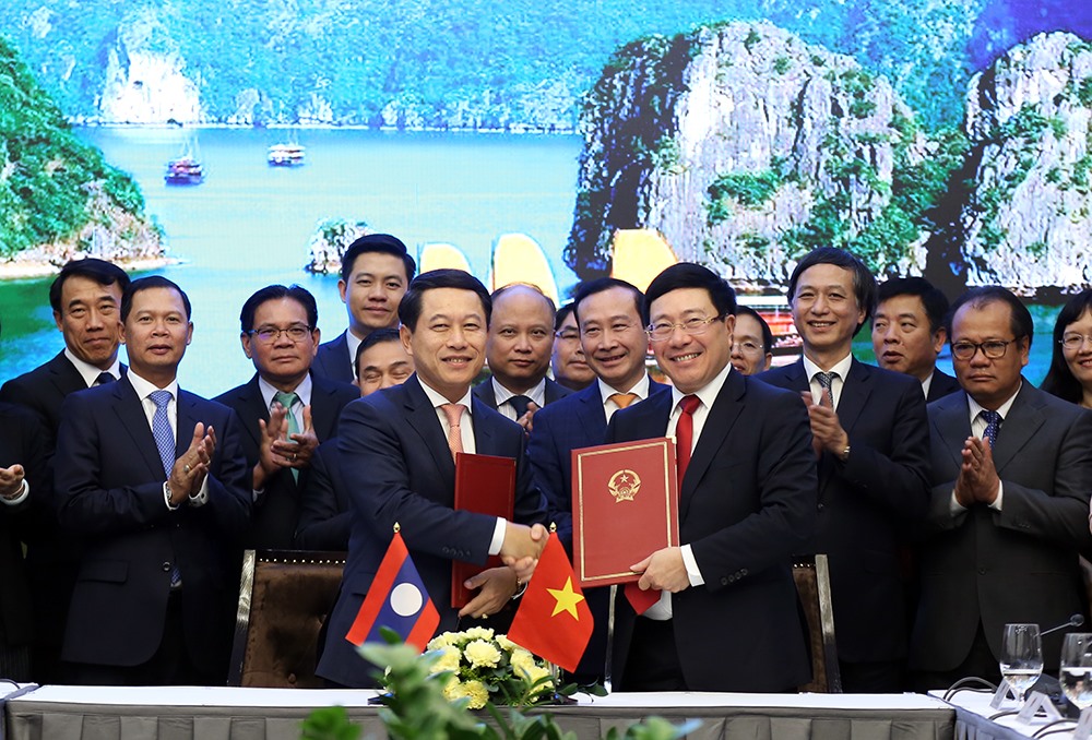 Phó Thủ tướng, Bộ trưởng Phạm Bình Minh và Bộ trưởng Ngoại giao Lào Saleumxay Kommasith đã ký Chương trình Hành động về hợp tác giữa Bộ Ngoại giao hai nước về thúc đẩy hơn nữa công tác ngoại giao kinh tế giai đoạn 2020-2025. Ảnh: BNG.