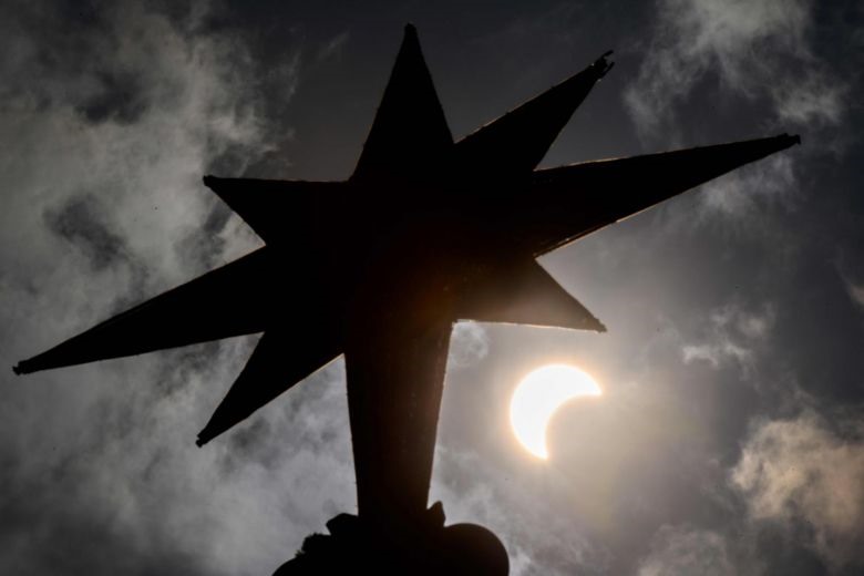 Thời khắc Mặt trăng bắt đầu che khuất Mặt trời được chụp từ ngôi sao trên cây thông Giáng sinh ở Bangkok, Thái Lan. Ảnh: AFP.