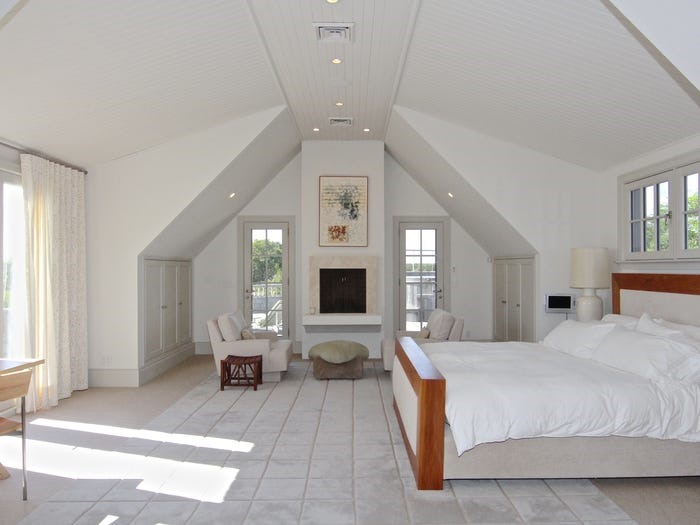 Phòng ngủ chính có trần cao và cửa kính mở ra ngoài trời.