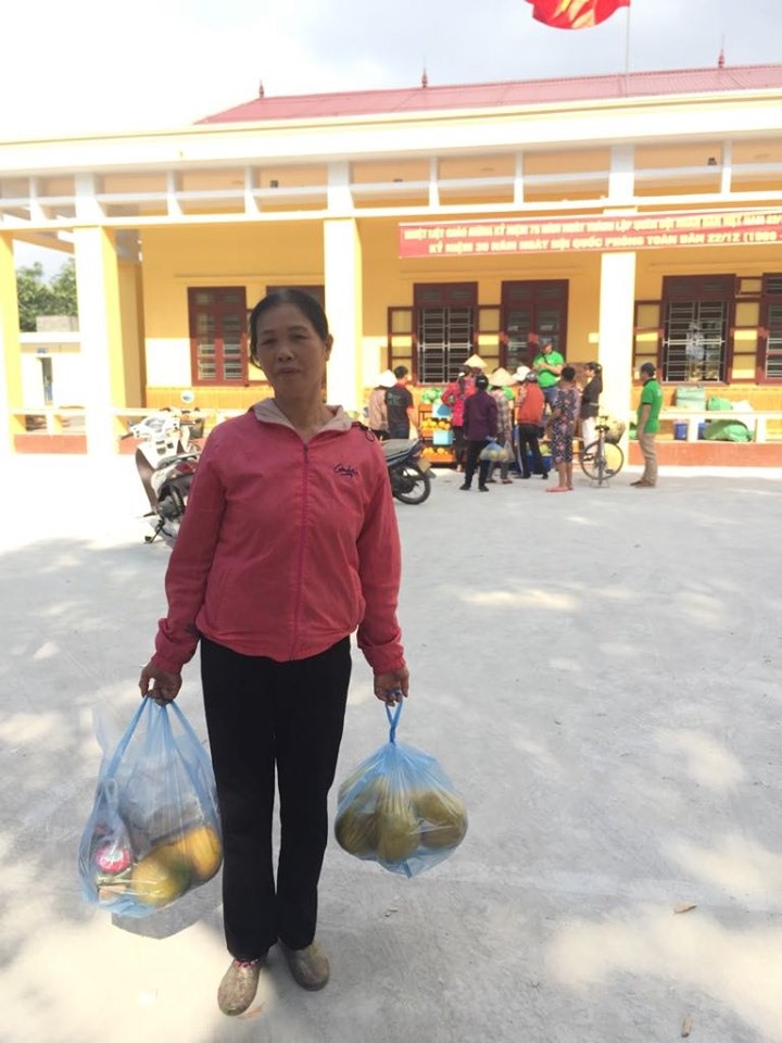 Bà Hà Thị Phòng với túi đồ mua được từ chương trình hỗ trợ đưa hàng Việt về nông thôn