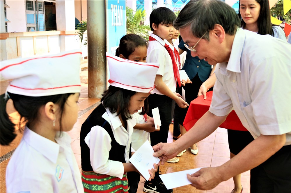 Ông Lê Vinh - Phó TGĐ Công ty CP Quốc tế AIC thăm hỏi và trao tận tay những em học sinh các suất học bổng. Ảnh: Bảo Trung