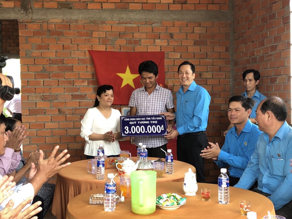 Ông Lưu Nhơn Đức - Chủ tịch Công đoàn Giáo dục tỉnh Tiền Giang trao quà cho gia đình từ quỹ tương trợ của ngành.