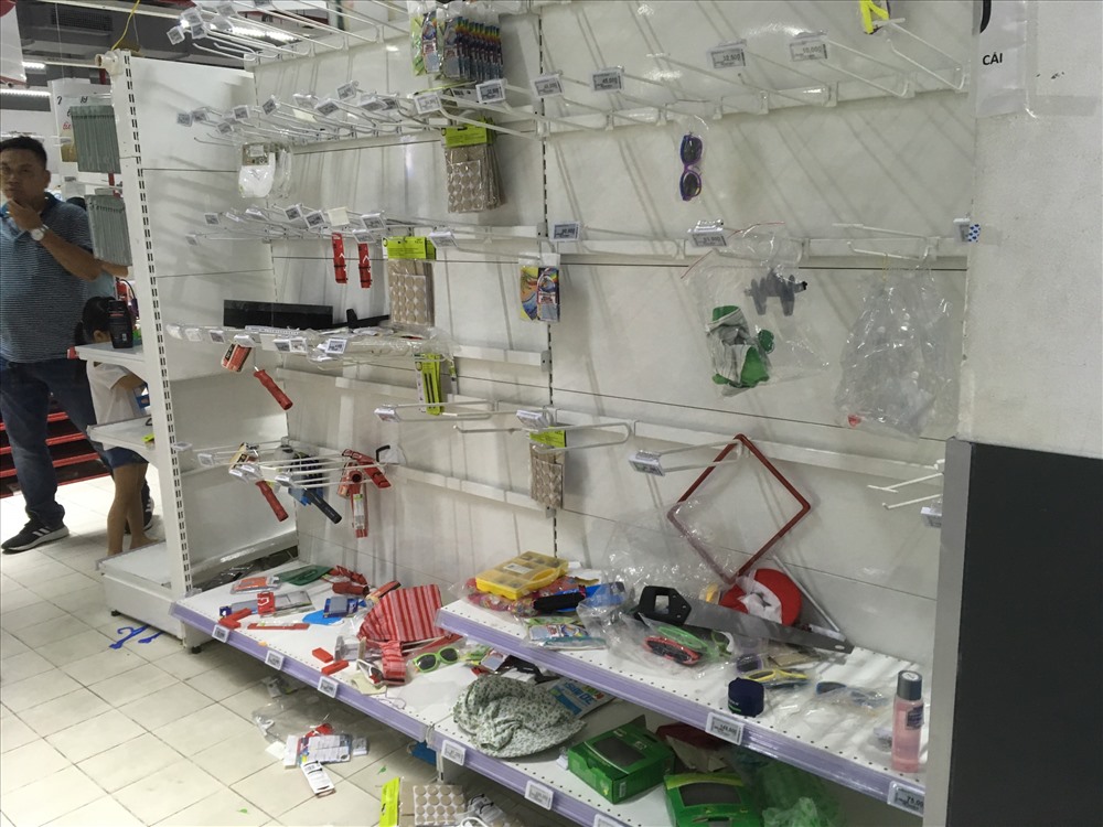 Người tiêu dùng tranh nhau lựa chọn khiến hàng hóa rơi khỏi giá đỡ và nằm vương vãi trên sàn nhà. Nhân viên Auchan phải liên tục xếp lại hàng hóa, nhưng không kịp trước sự “vỡ trận” của người mua hàng.