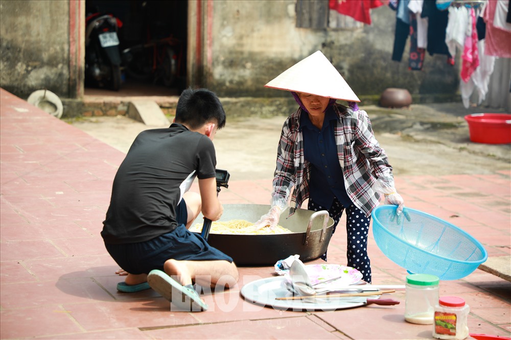 Bà Tân và con trai đang thực hiện quay 1 clip để đăng tải lên mạng xã hội. Ảnh: Phương Anh.