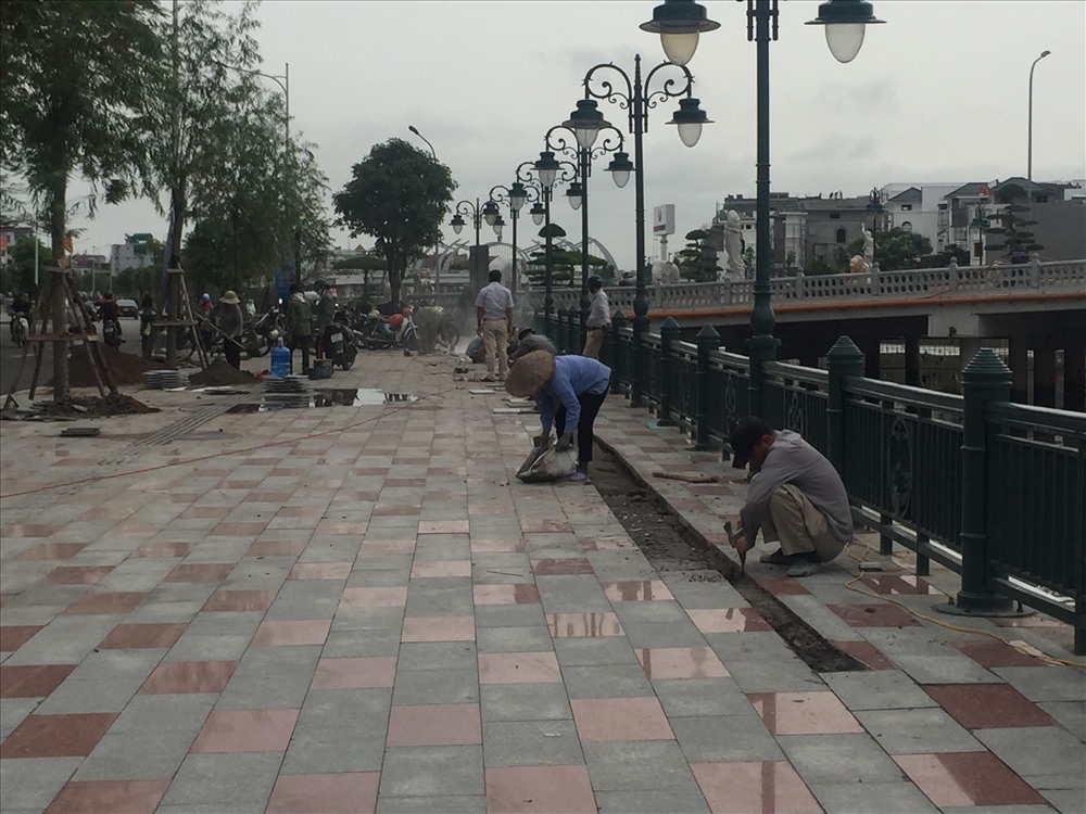Thợ đang sửa lại vỉa hè đoạn gần chân cầu sang phường Hạ Lý