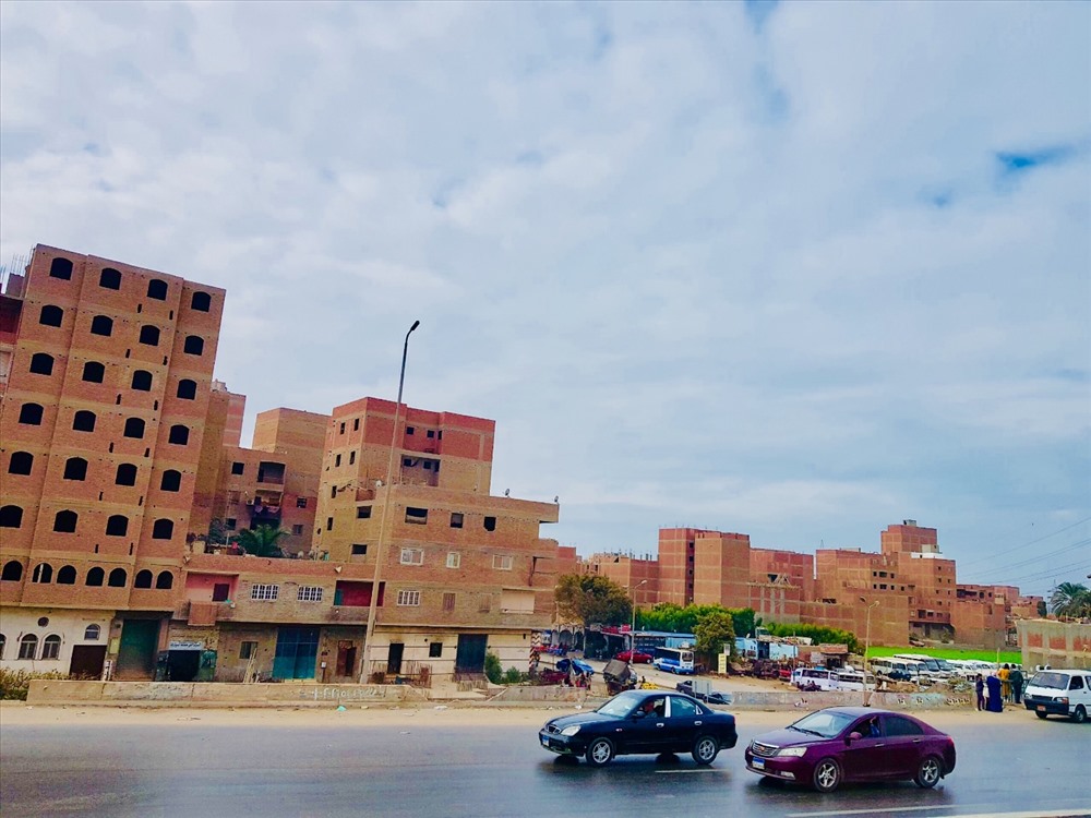 Một góc thủ đô Cairo Với dân số khoảng 19.5 triệu người, Cairo hiện là thành phố đông dân xếp thứ hai Châu Phi và thứ 16 trên thế giới. Đô thị này có diện tích chỉ khoảng 453 km2 nhưng tập trung tới 1/5 dân số của cả nước. Do nằm sát sa mạc và thấp hơn mặt biển nên Cairo rất bụi bặm, cả thành phố lúc nào cũng như có một lớp sương mù bao quanh. Do khí hậu khắc nghiệt nên nhà cửa ở đây thường được xây rất đơn giản, thường là bằng gạch bùn và không sơn hay tô trát cầu kì ở bên ngoài.