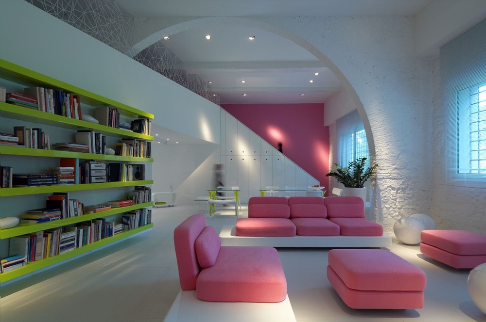 Sự kết hợp giữa ba màu: tường màu trắng, kệ sách màu xanh lá cây và bộ sofa màu hồng tạo nên sự tương phản cao cho phòng khách thêm hiện đại.