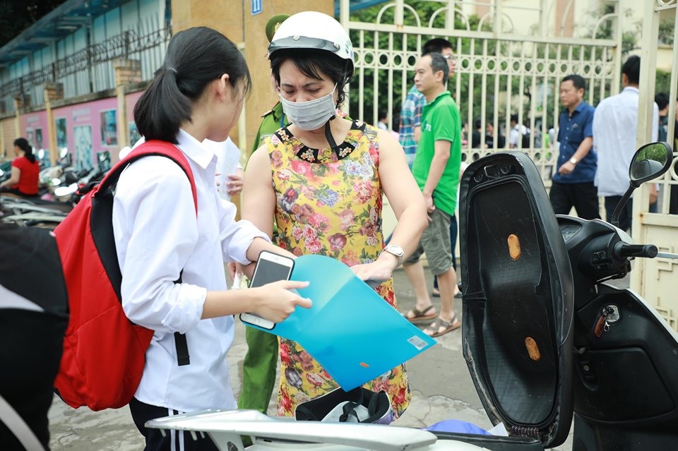 Ghi nhận của phóng viên Lao Động tại điểm trường THCS Nam Trung Yên, phụ huynh đưa con đến trường làm thủ tục từ sớm, chuẩn bị sẵn sàng các giấy tờ liên quan. Ảnh: Phương Thắng