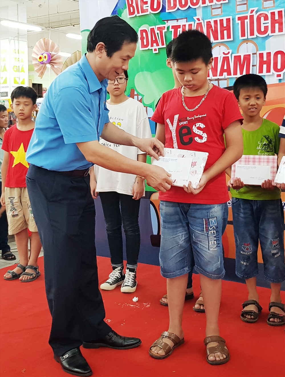 Đồng chí Trần Kim Long, Phó chủ tịch LĐLĐ tỉnh Ninh Bình tặng quà cho các em học sinh. Ảnh: NT