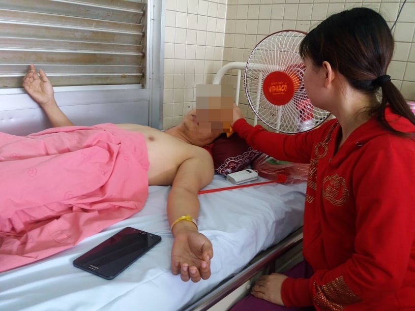 Chị Liễu đang chăm sóc cho anh Thịnh, bệnh nhân bị khoan xuyên đinh chân nhầm