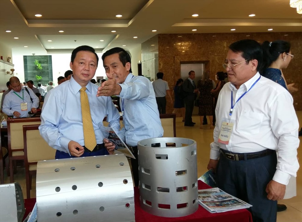 Bộ trưởng Bộ TN&MT - Trần Hồng Hà (bìa trái) tham quan mô hình đề chắn sóng biển bên hành lang hội thảo.  Ảnh: Minh Quân