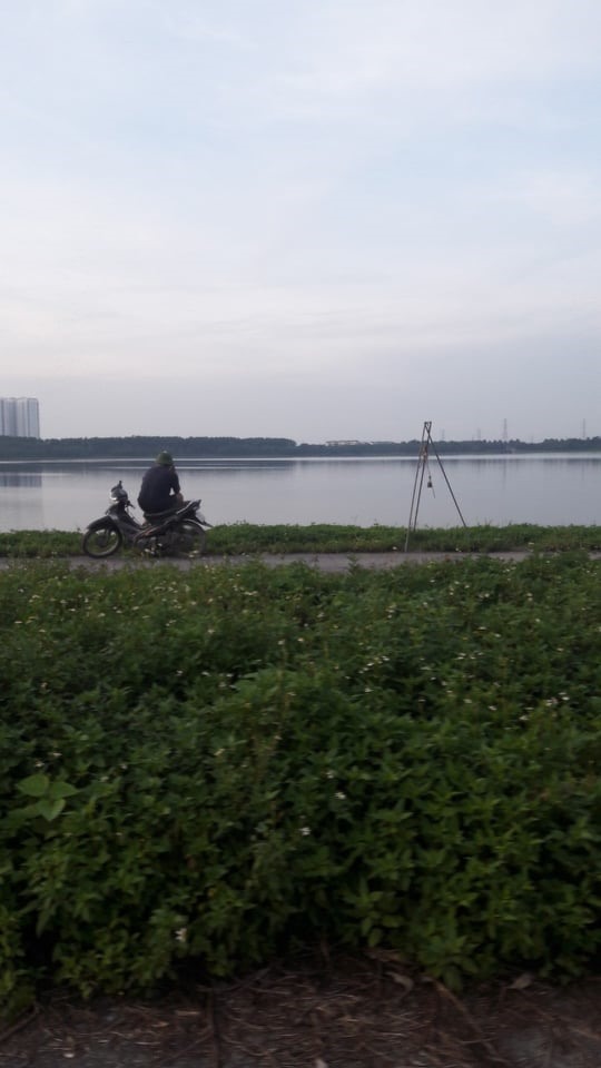 Người đàn ông kiên nhẫn ngồi chờ để cân cá khi đánh bắt xong tại khu vực cụm hồ điều hòa Yên Sở. Ảnh: Đ.T