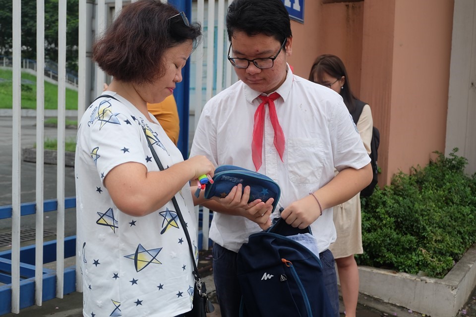 Tại điểm thi trường THCS Nam Trung Yên, nhiều phụ huynh đang giúp con mình kiểm tra lại đồ dùng mang vào phòng thi. Ảnh: Hà Phương