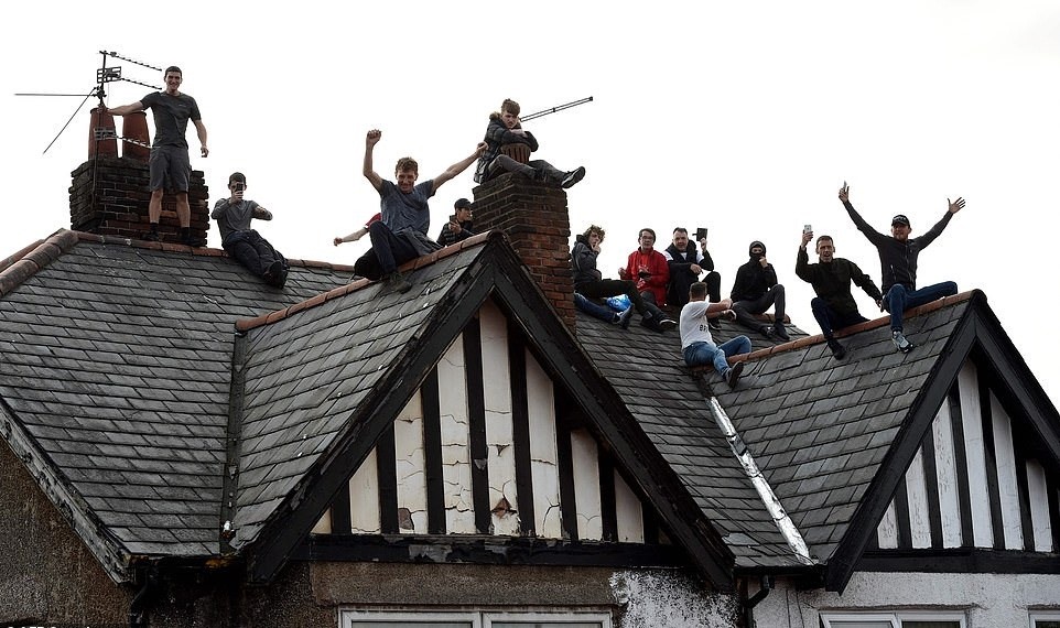 Nhiều CĐV muốn chọn cho mình vị trí quan sát tốt nhất, ngay cả việc trèo lên mái nhà. Ảnh: Getty Images.