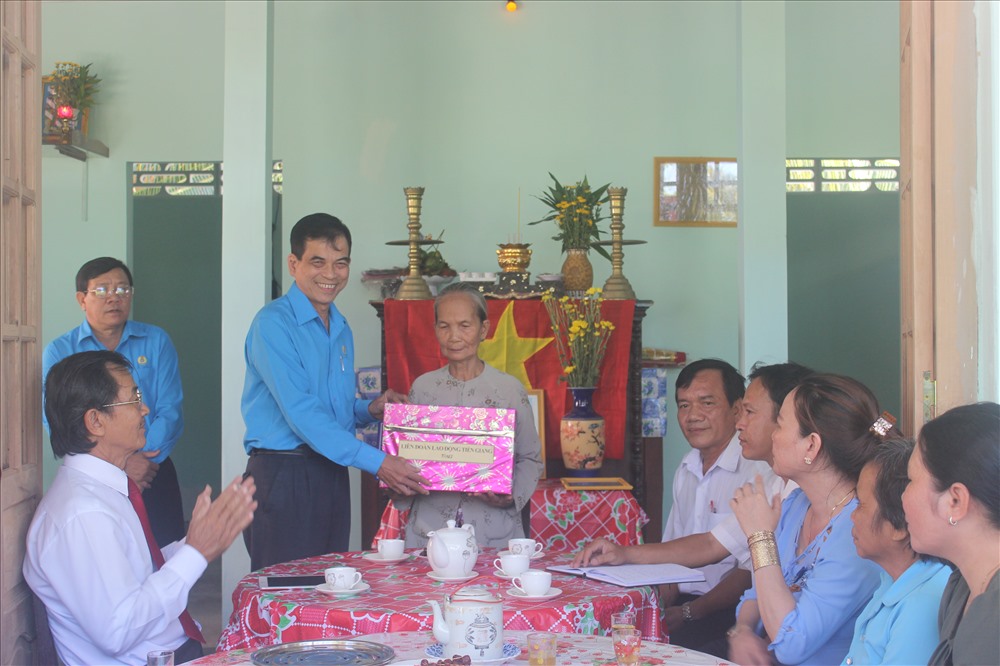 Chủ tịch LĐLĐ tỉnh Tiền Giang tặng quà cho gia đình bà Tính tại lễ trao nhà.