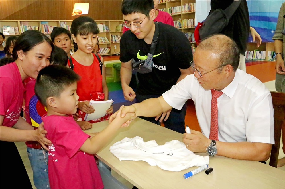 Ông Park lần lượt ký tặng cho các em nhỏ của Trung tâm Việt - Hàn chung tay chăm sóc, đang xếp hàng dài chờ đợi. Ảnh: Dương Thu