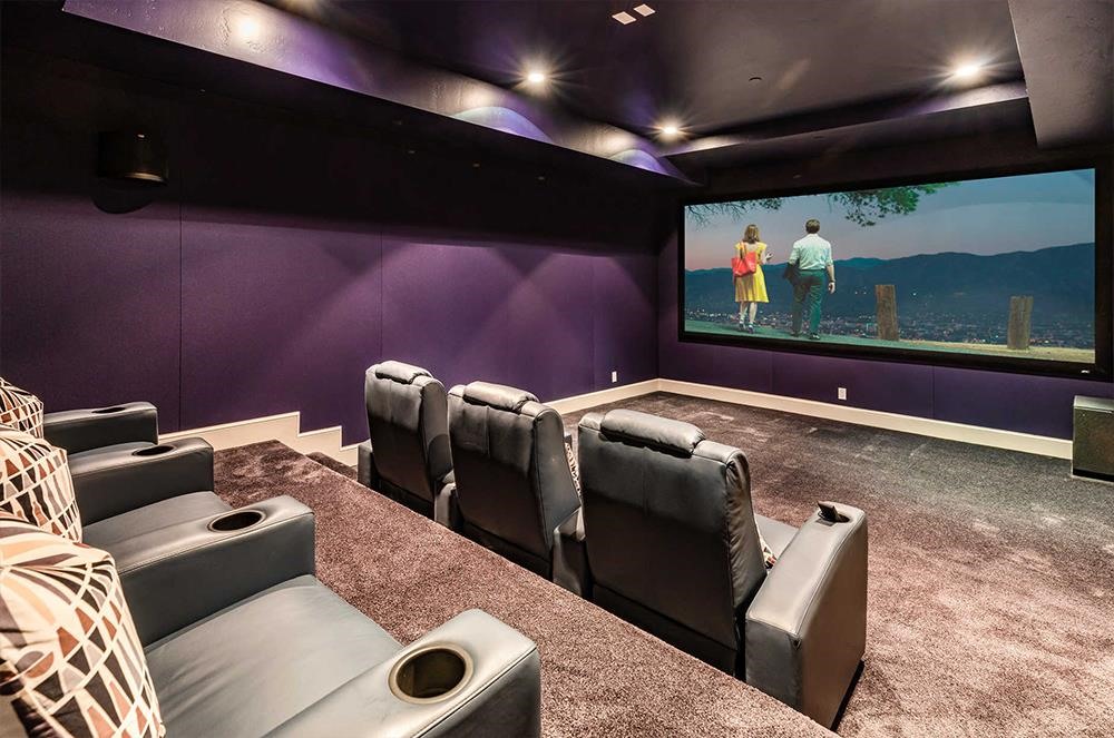 Rạp chiếu phim trong nhà với tông màu tím chủ đạo cùng bộ ghế được bọc da.