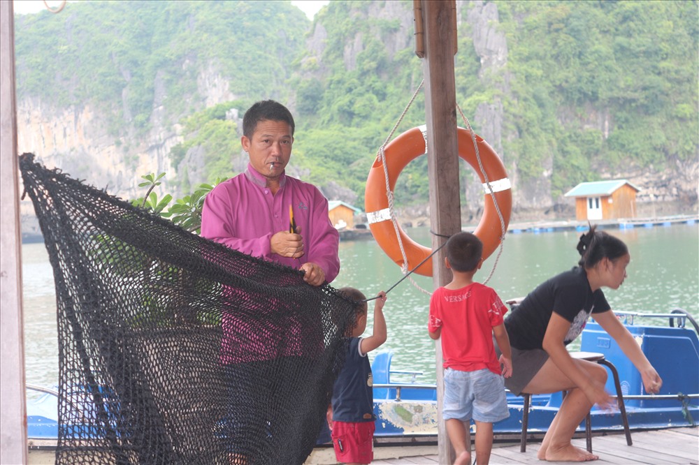Ngư dân tranh thủ vá lưới. Ảnh: Nguyễn Hùng